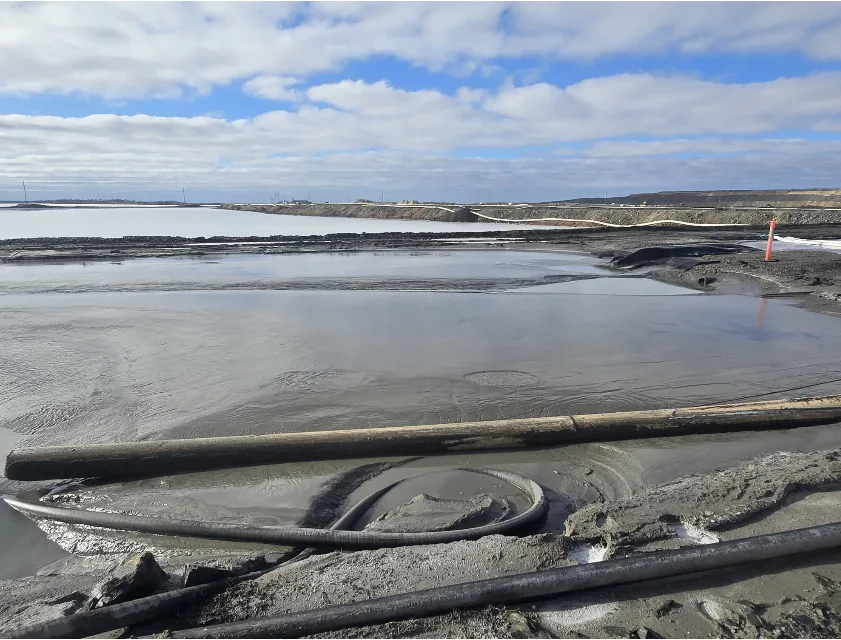 Consolidated sediment and hoses at a tailings site